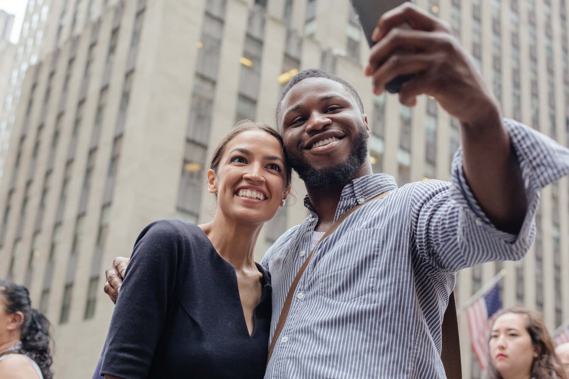 Alexandria Ocasio-cortez Taking Picture With A Man Background