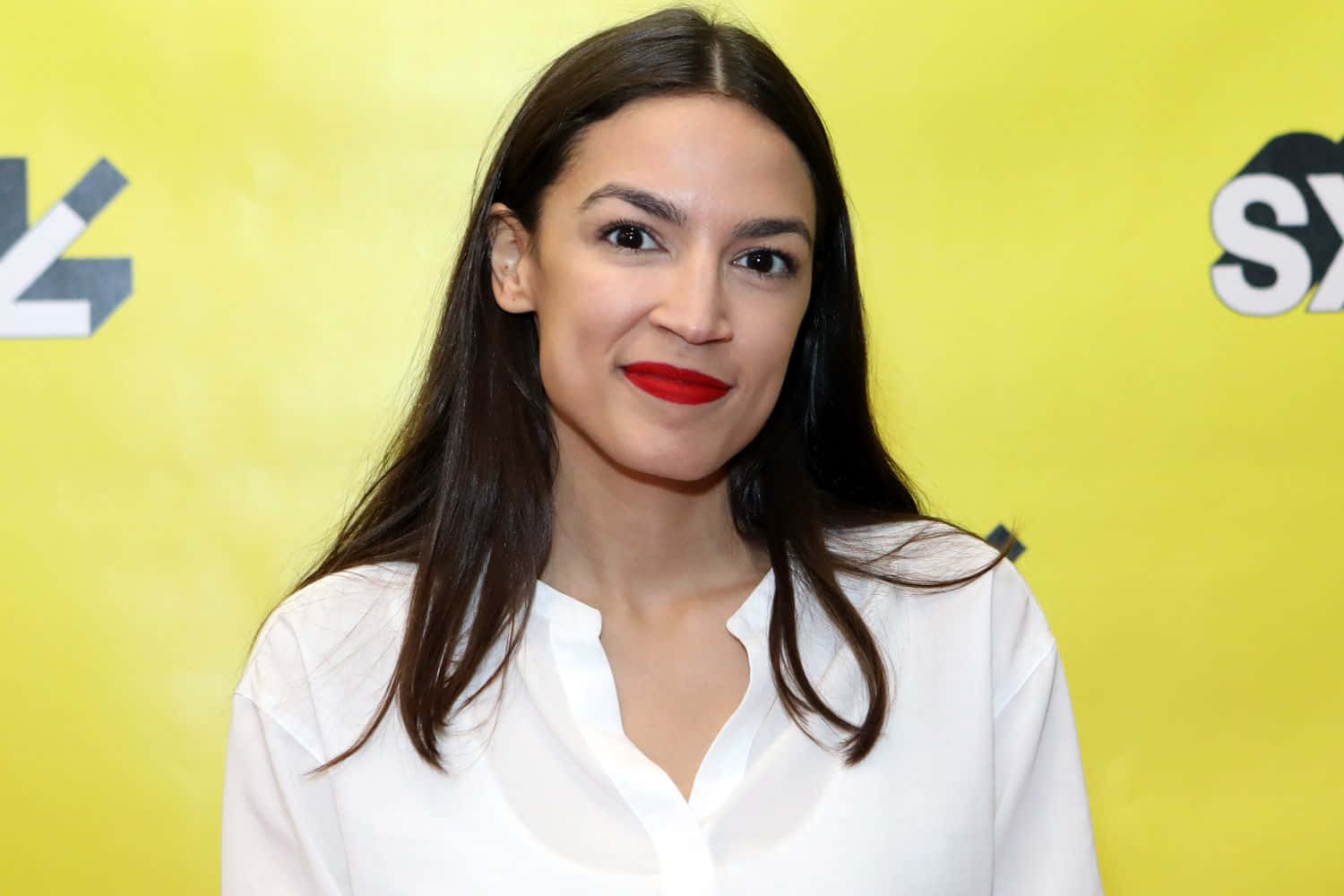 Alexandria Ocasio-cortez, Vibrantly Posed Against A Yellow Backdrop Background