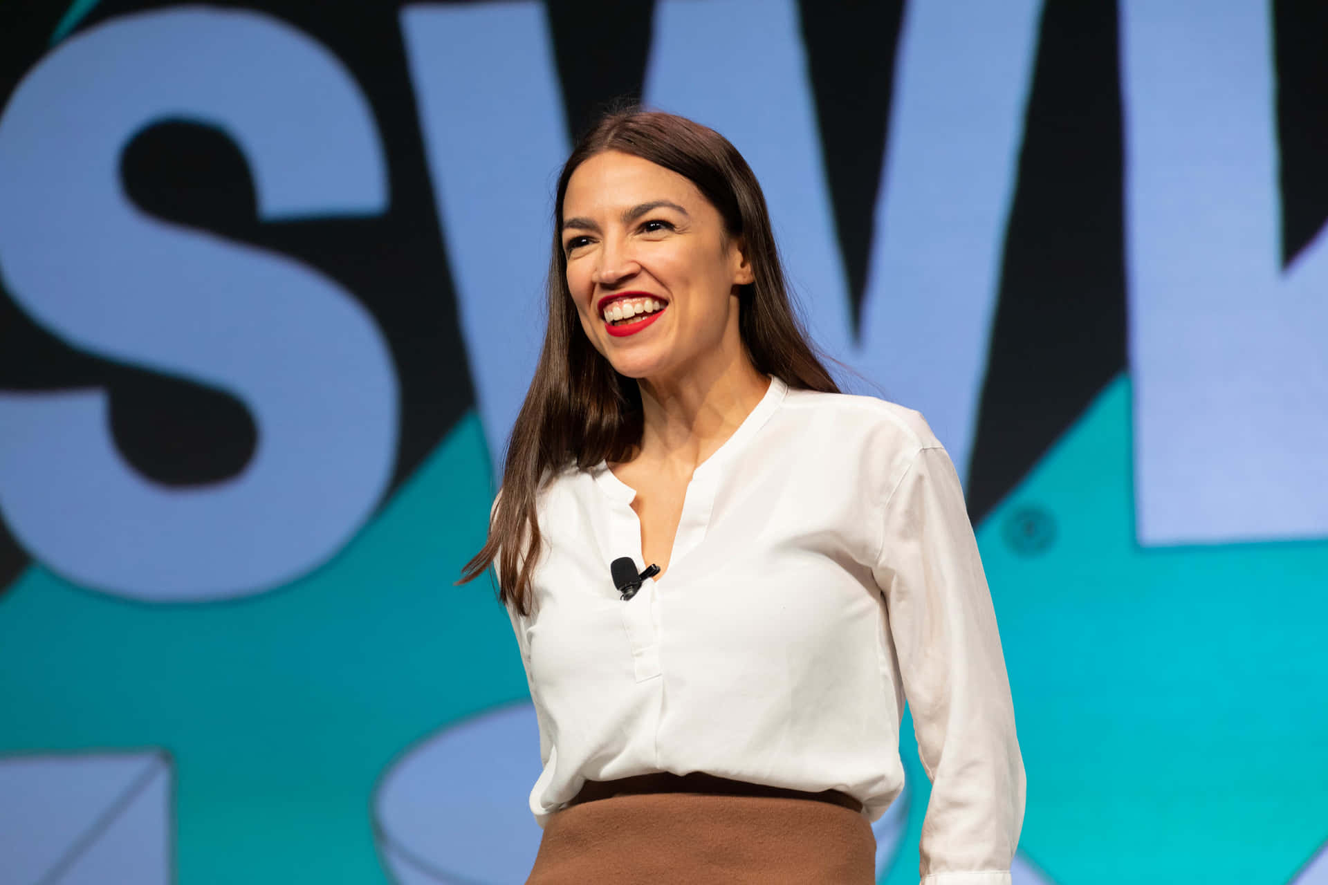 Alexandria Ocasio-cortez With A Blue Backdrop Background