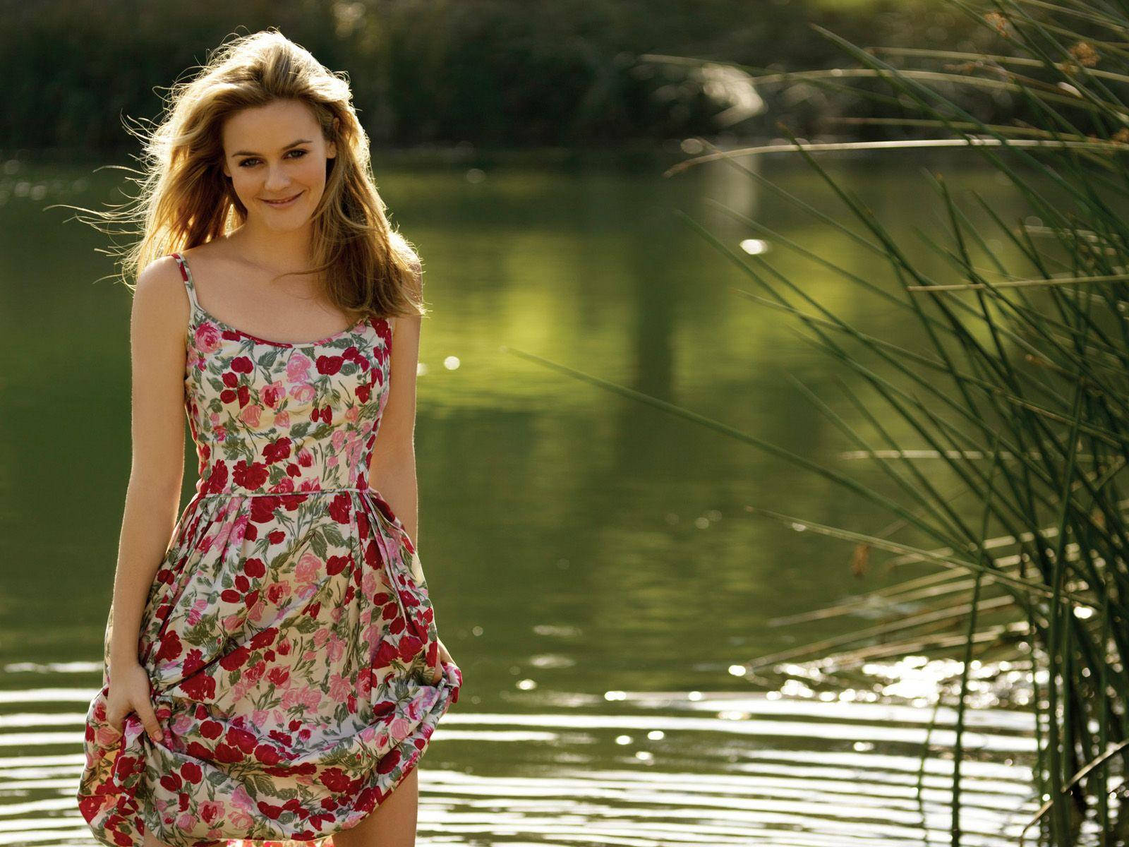 Alicia Silverstone In Front Of The Lake Background