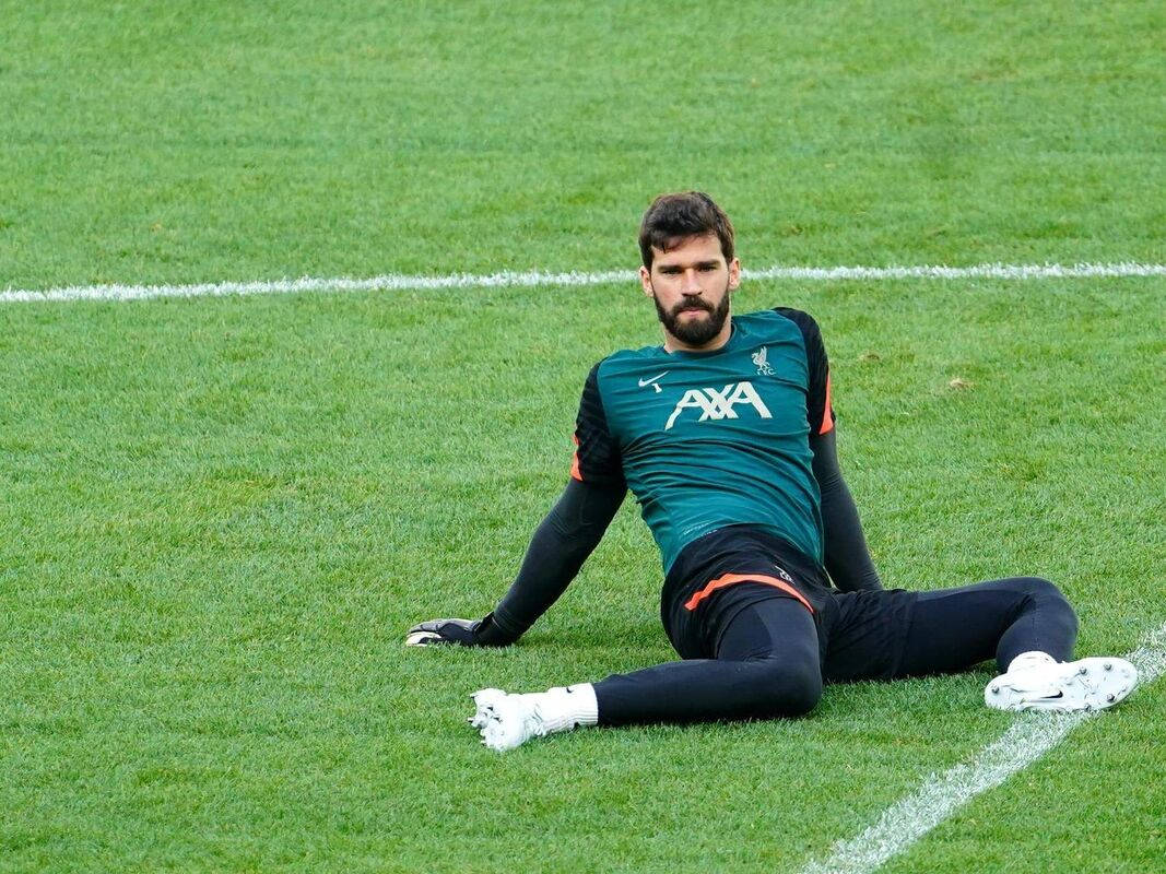 Alisson Becker Sitting On The Field Background