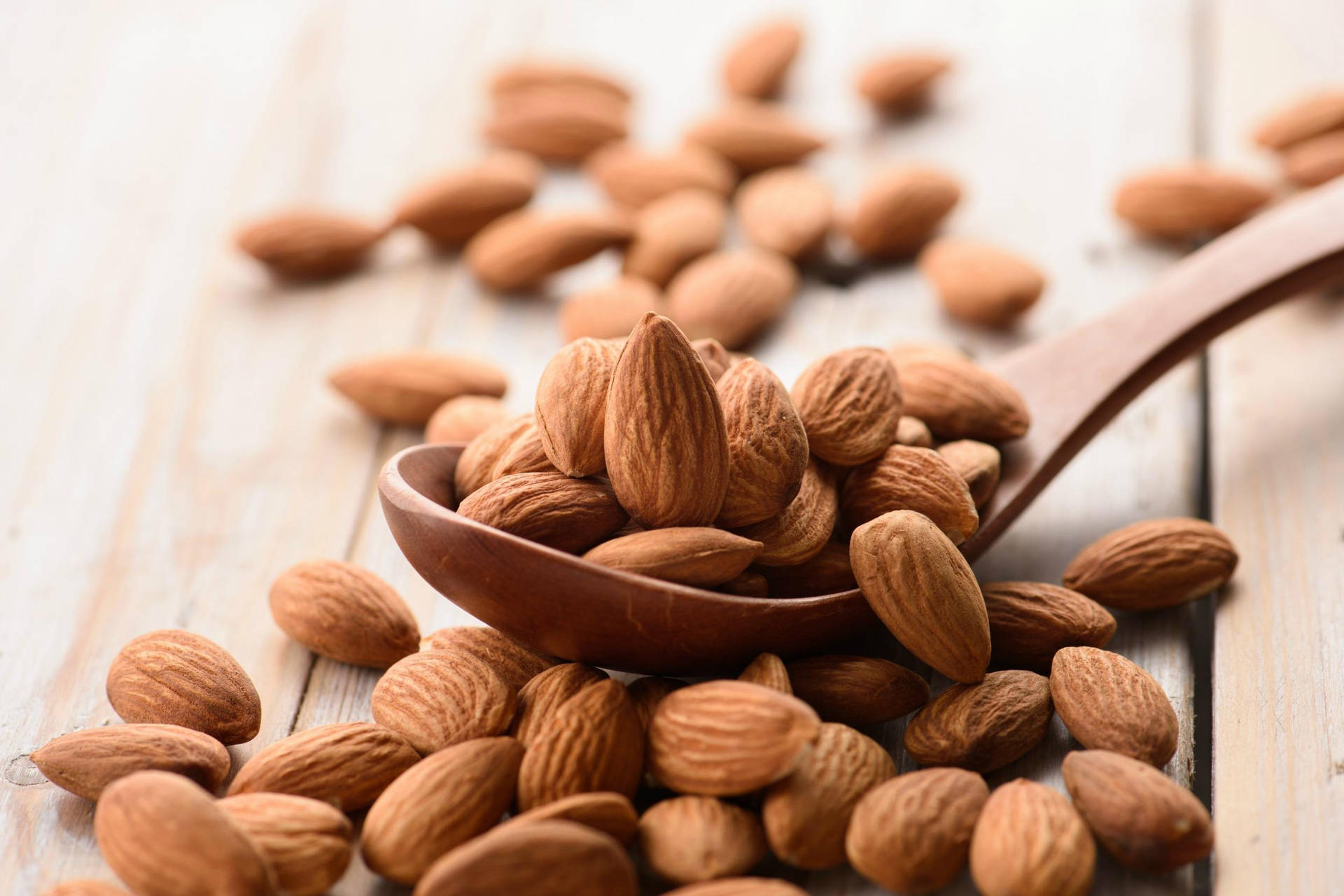 Almond Nuts On Wooden Spoon Background