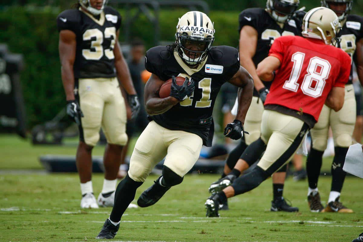 Alvin Kamara #41 Of The New Orleans Saints In Action On The Field Background