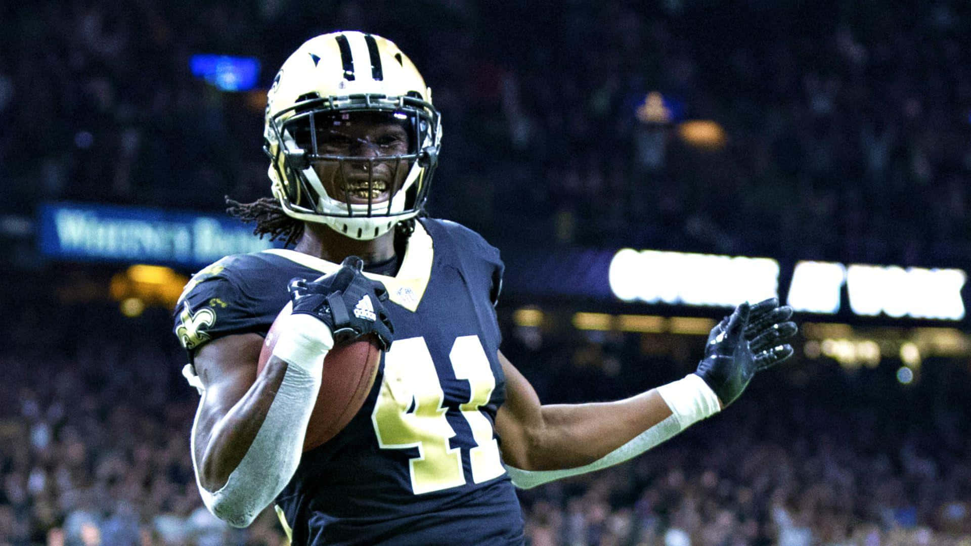 Alvin Kamara Of The New Orleans Saints Peers Downfield After Breaking Away From Defenders. Background