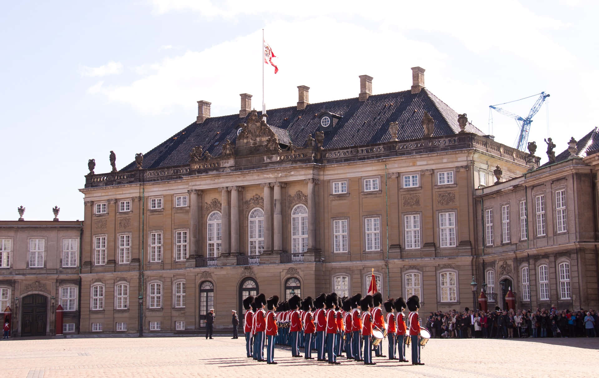 Amalienborg Palace With People Dressed In Red Background