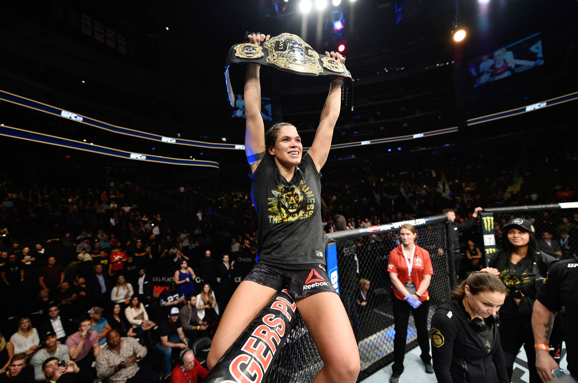 Amanda Nunes Raising Championship Belt Background