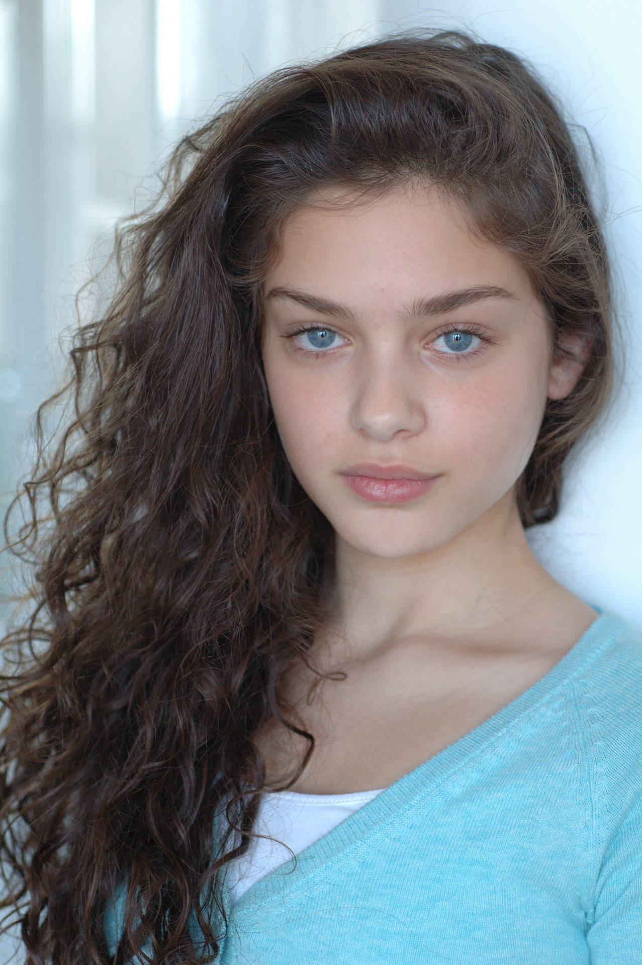 Amazing Charisma: Blue-eyed Girl With Voluminous Curly Hair Background