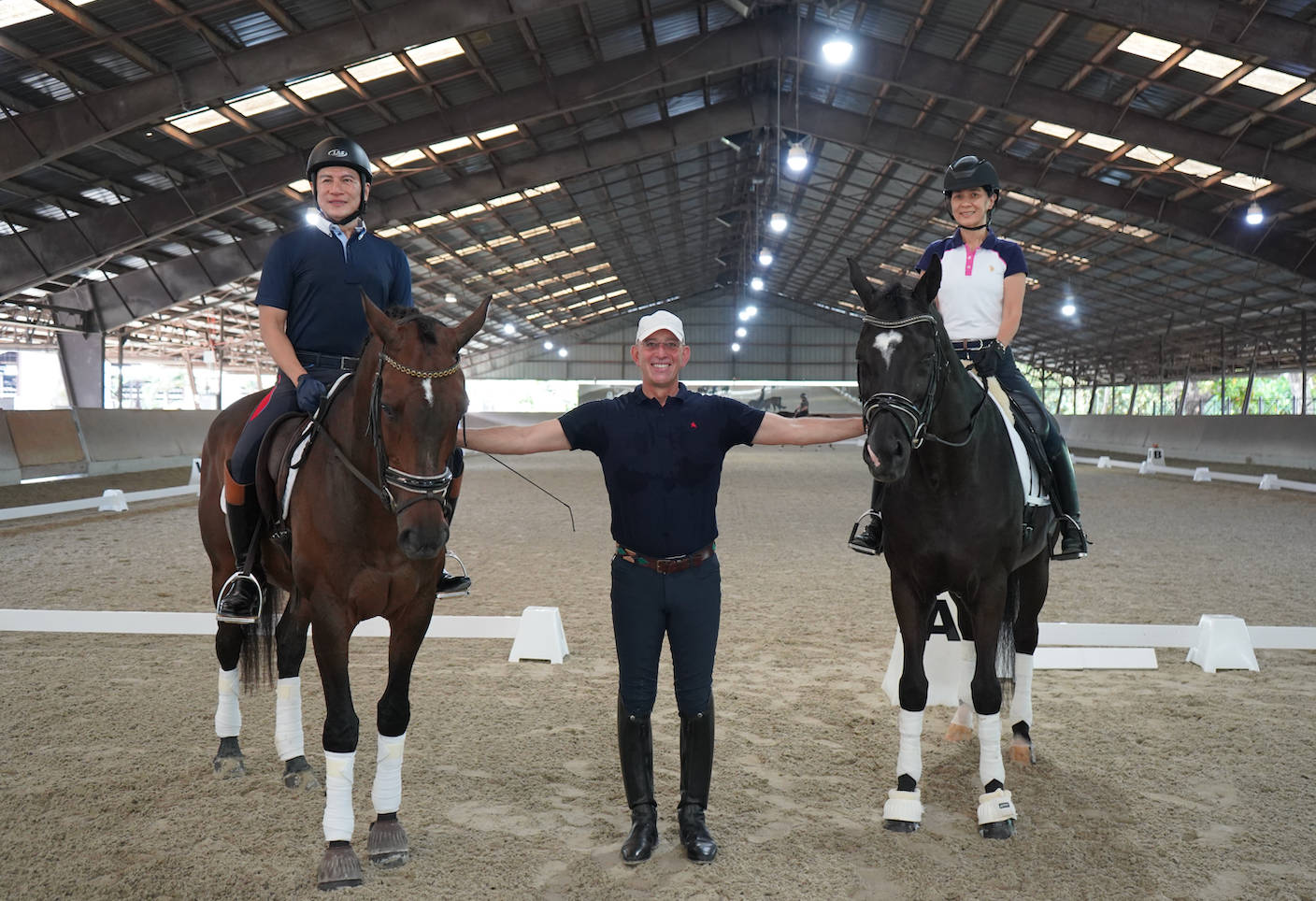 Amazing Equestrian Trainer With Two Horseback Riders Background