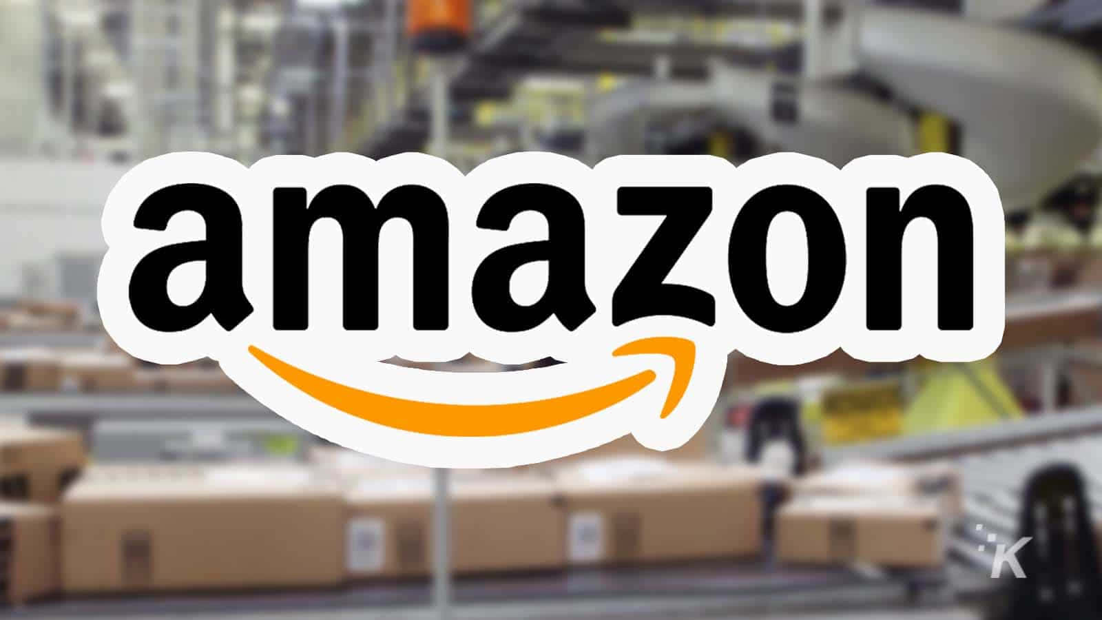 Amazon Uk Logo Against Blurry Warehouse