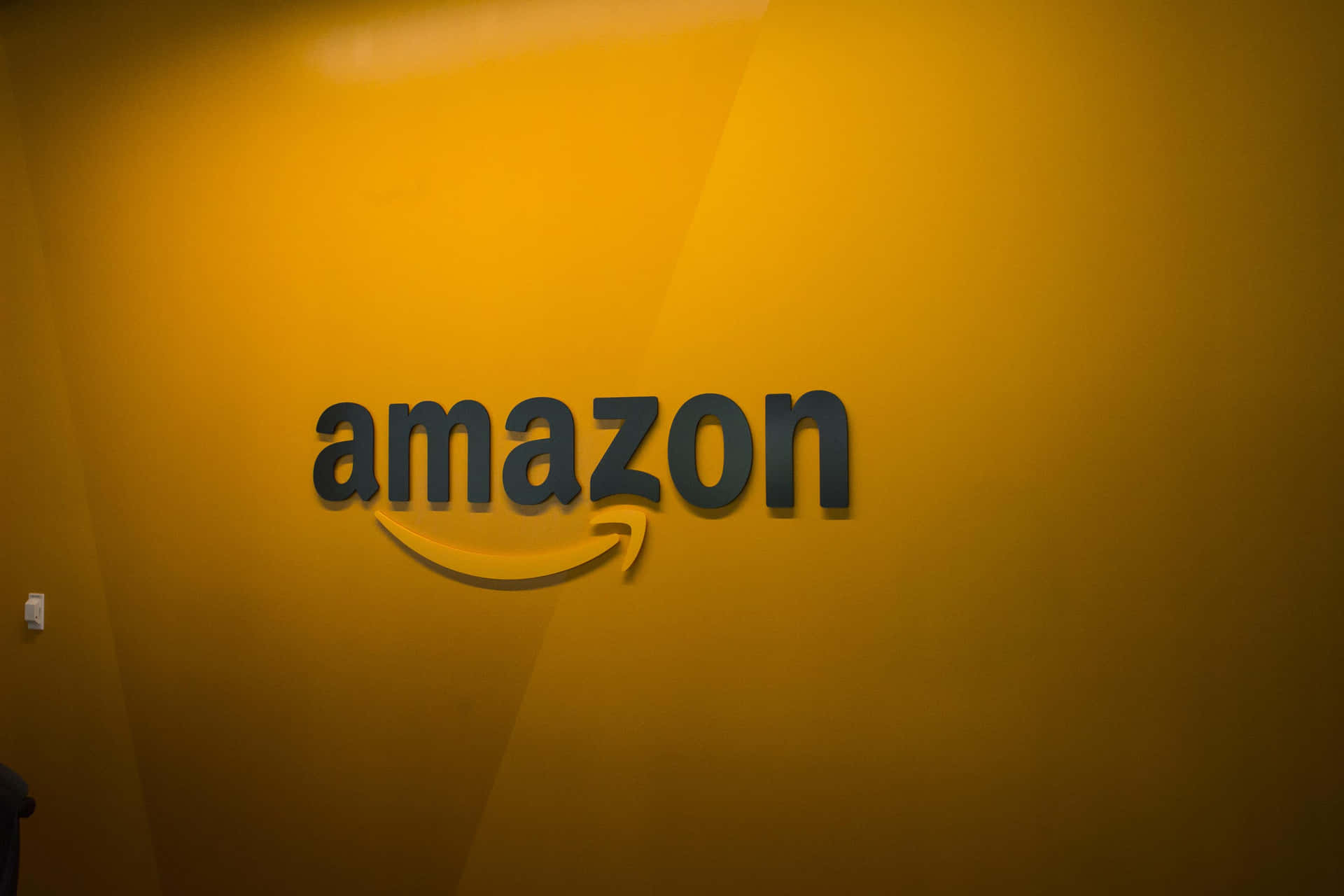 Amazon Uk Logo In Yellow-orange Wall Background
