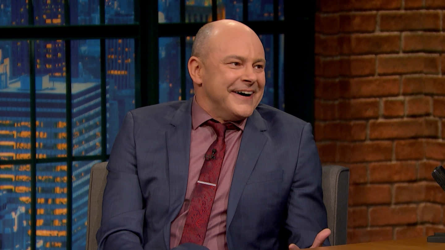 American Actor And Comedian Rob Corddry Posing Against A Colorfully Painted Wall. Background