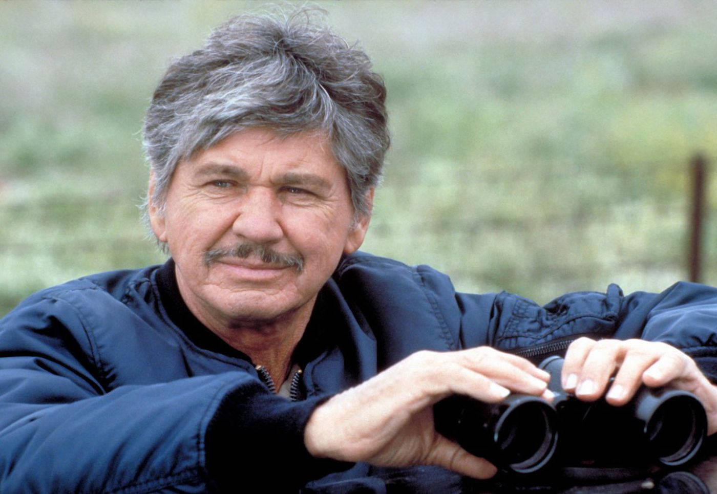 American Actor Charles Bronson With Binoculars Background