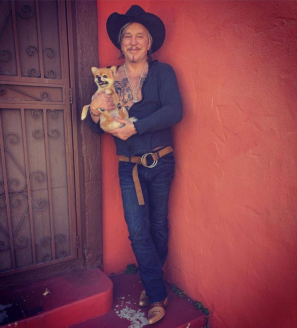 American Actor Mickey Rourke With Dog Ruby Background