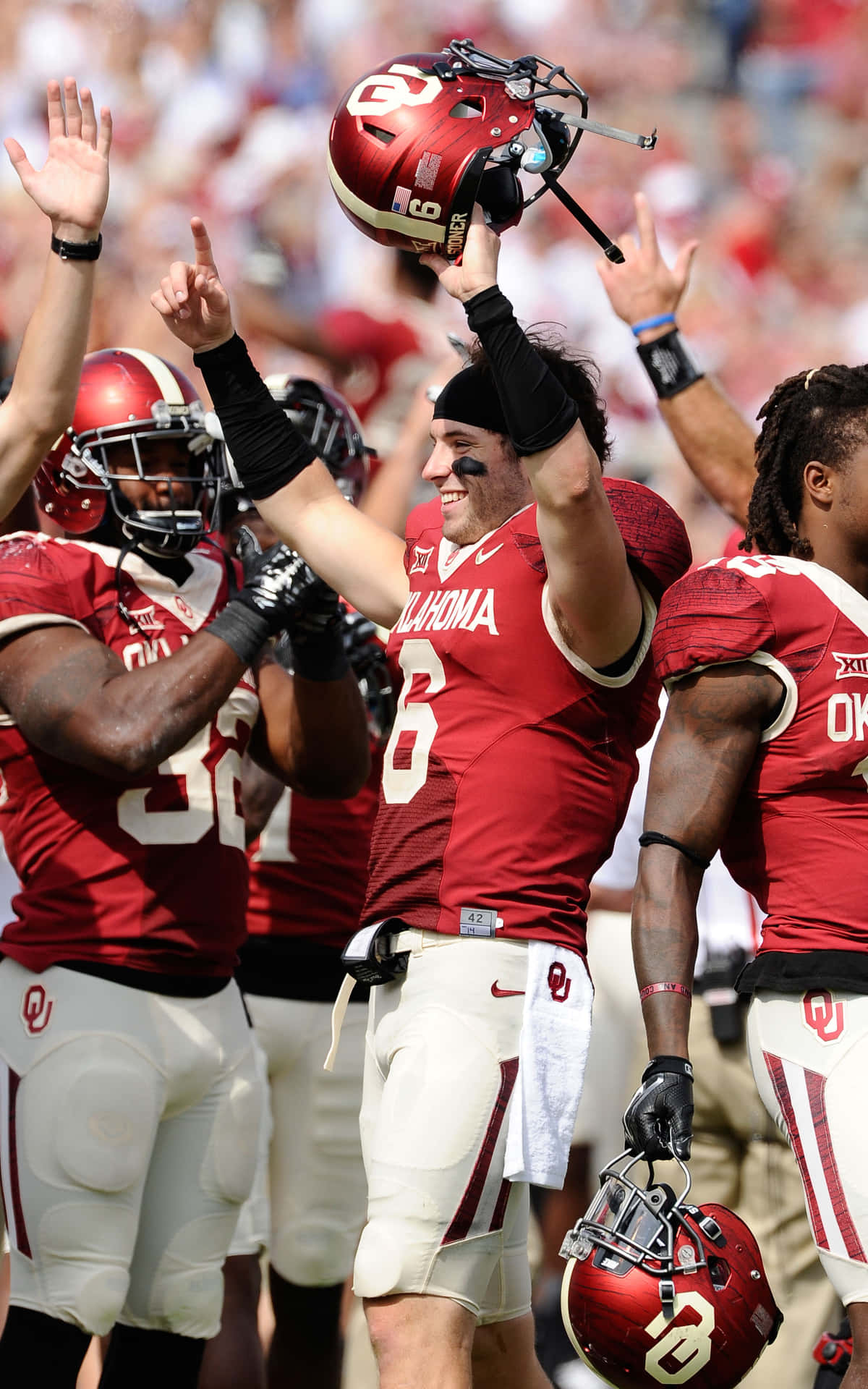 American Football Quarterback Baker Mayfield Stands With A Determined Expression On The Field Background