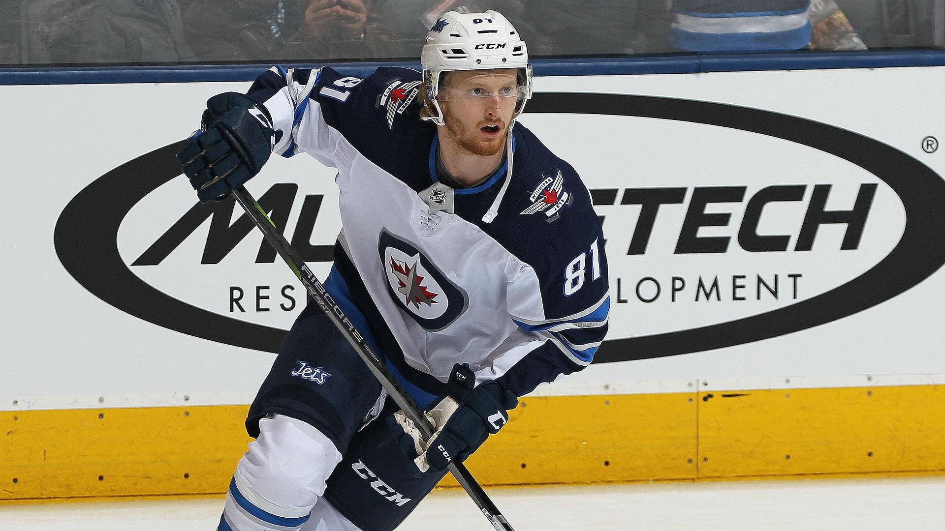 American Ice Hockey Player Kyle Connor Gliding On The Rink Background