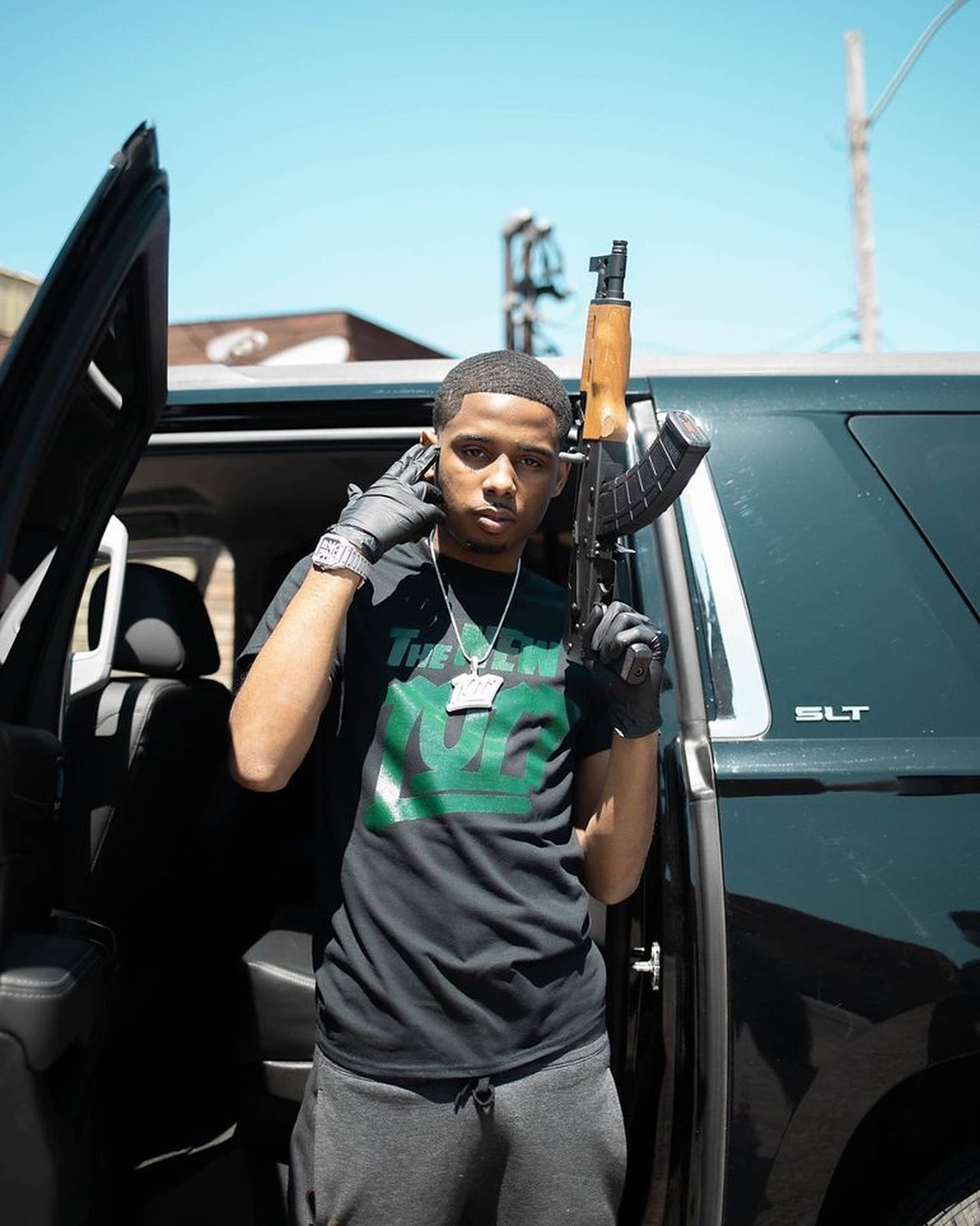 American Rapper Pooh Shiesty Posing With A Rifle