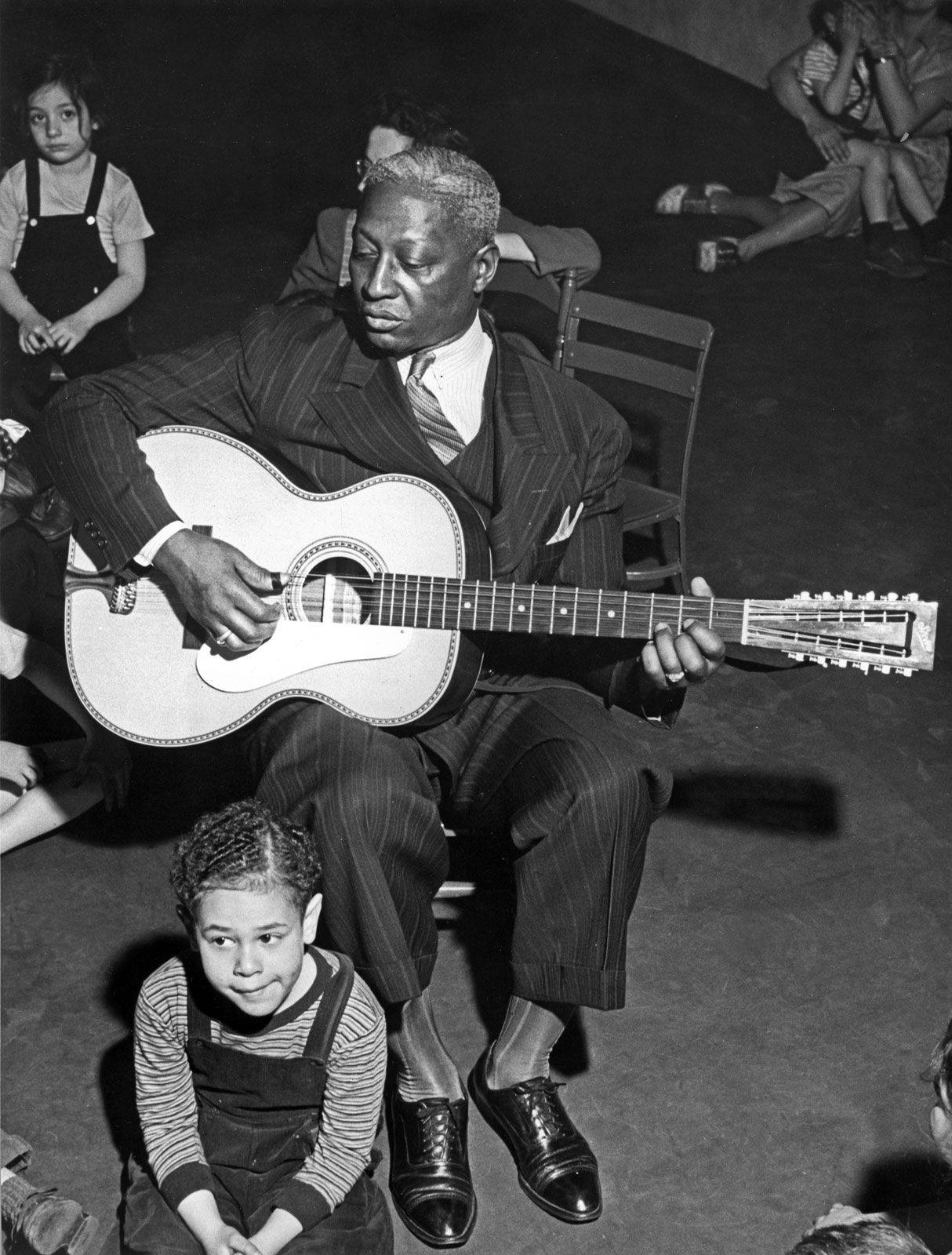 American Singer And Musician Leadbelly With Kids 1940s Photograph Background