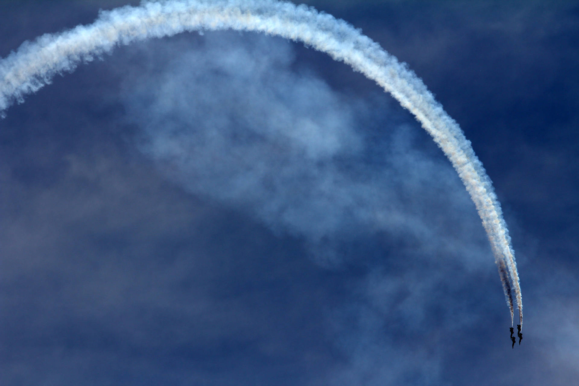 An Aerial Display Of Aerobatic Stunts By An Airplane Background