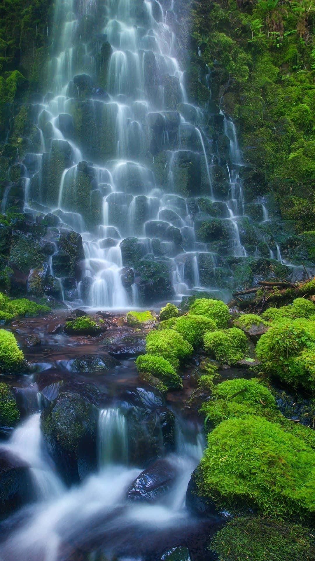 An Aerial View Of A Beautiful Waterfall Cascading Into A Magnificent Lake Background