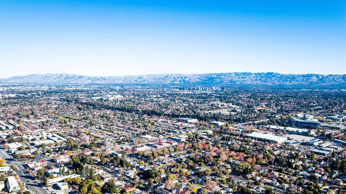 An Aerial View Of A City With Mountains In The Background