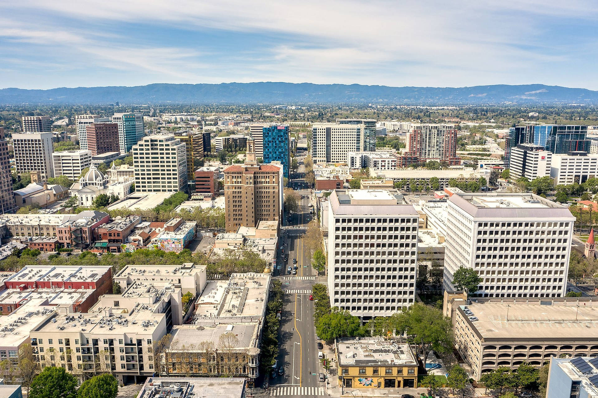 An Aerial View Of A City With Tall Buildings And Trees