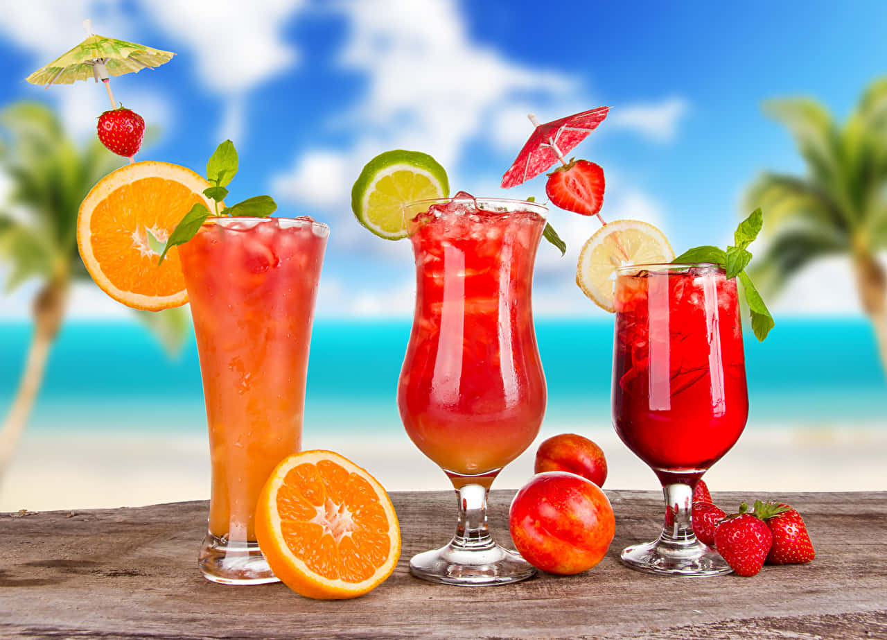 An Array Of Fresh Juices In Fancy Cocktail Glasses Background