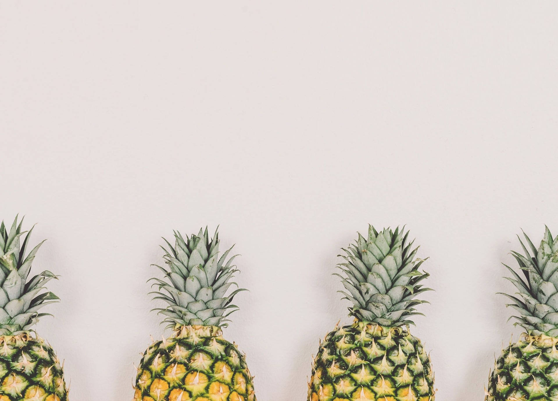 An Array Of Pineapples Of Different Sizes, Shapes, And Colors All Lined Up Side By Side. Background