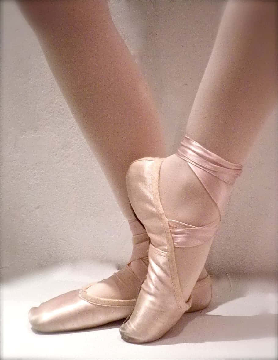 An Aspiring Ballerina En Pointe, On The Brink Of Their Dreams Background