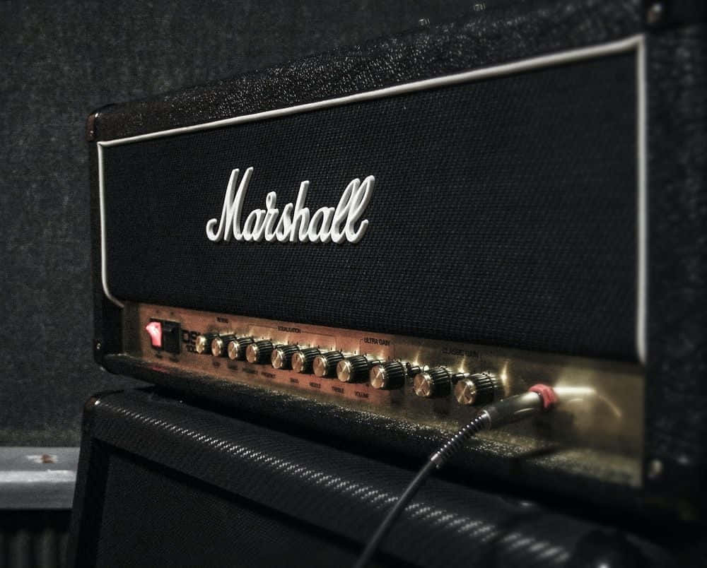 An Electric Guitar Laying In Front Of An Amp Ready For A Killer Gig Background