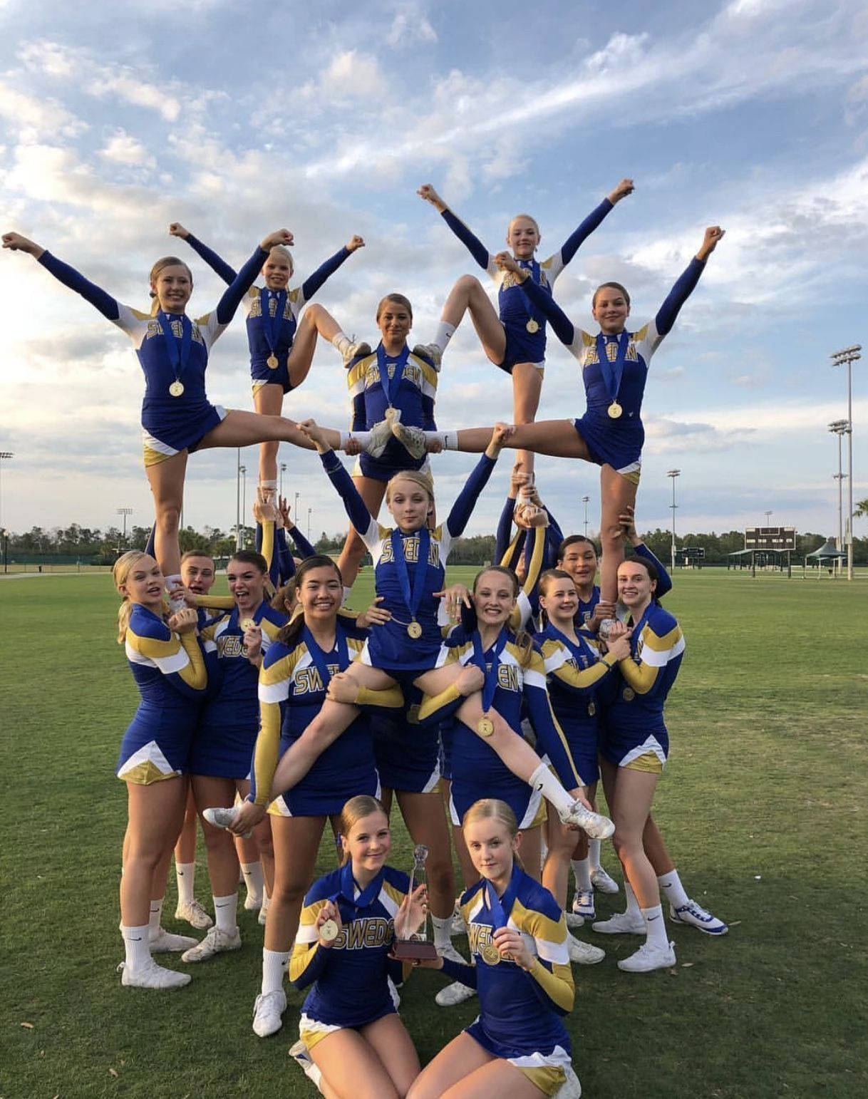 An Energetic Teen Cheerleader Practicing Outdoors Background