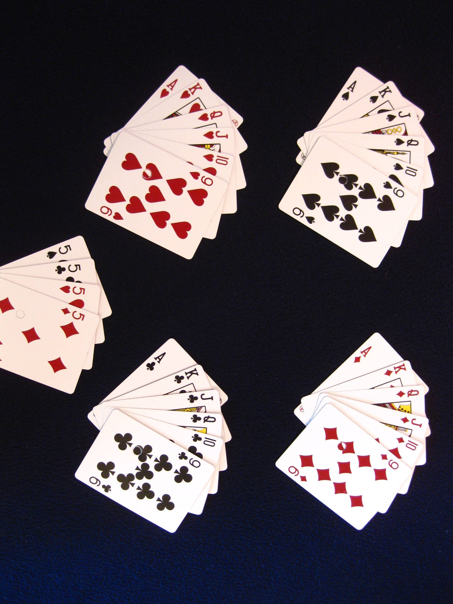 An Engaging Round Of Euchre With A Full Set Of Playing Cards On A Classy Green Felt Table.