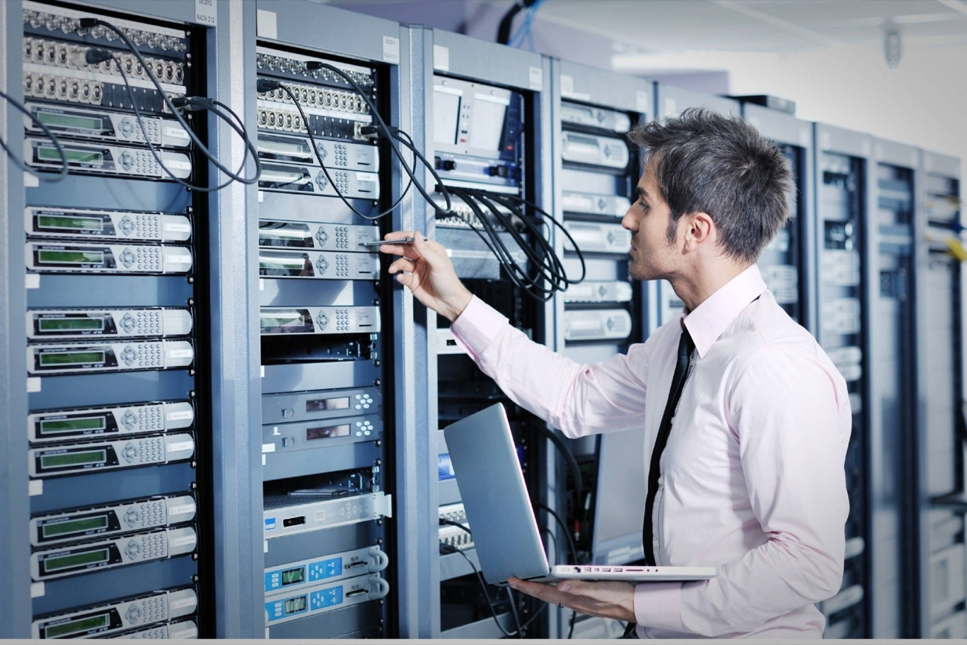 An Expert Technician Working On Data Server Racks Background