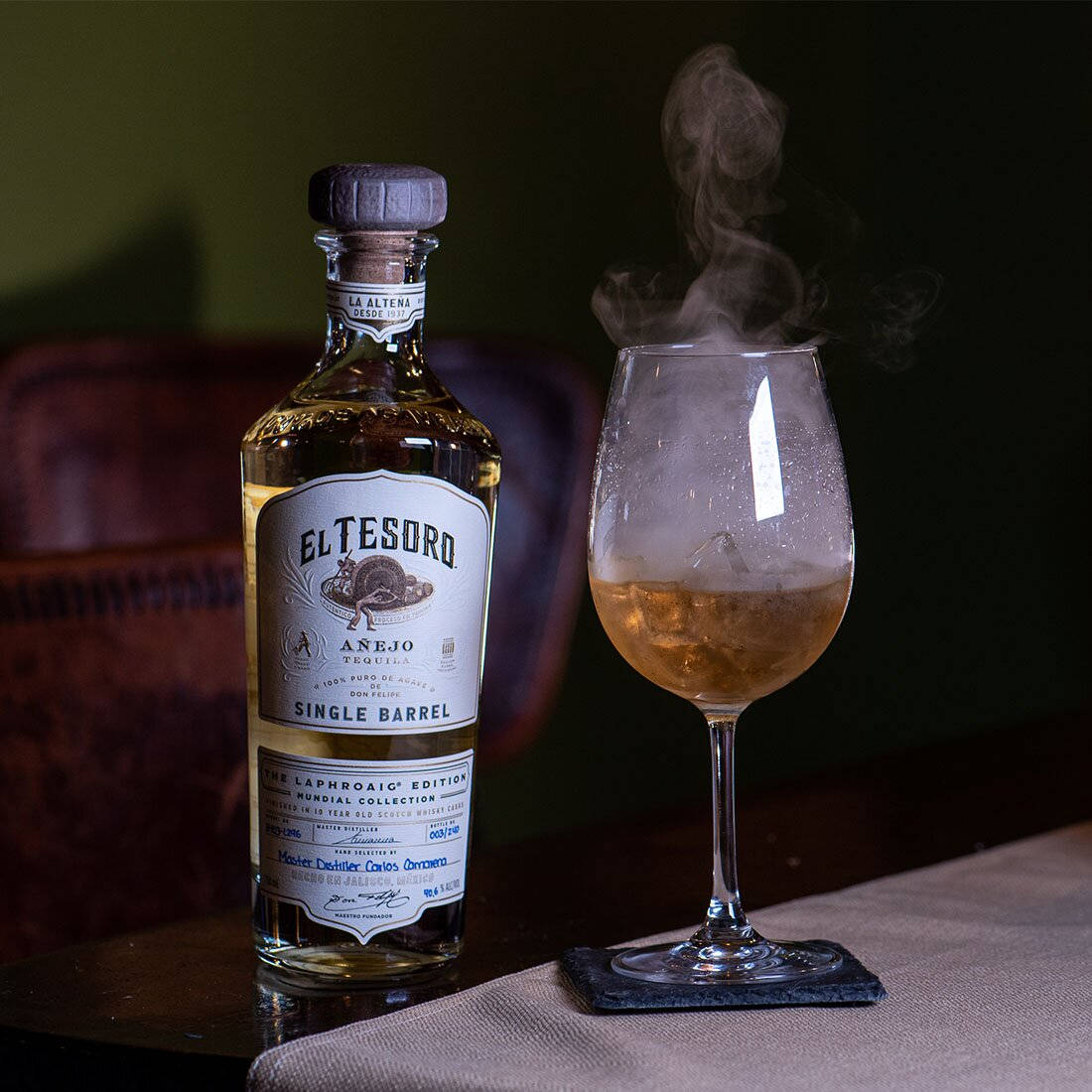 An Exquisite Bottle Of El Tesoro Tequila Showing Its Sophisticated Charm In A Smoky Ambiance.