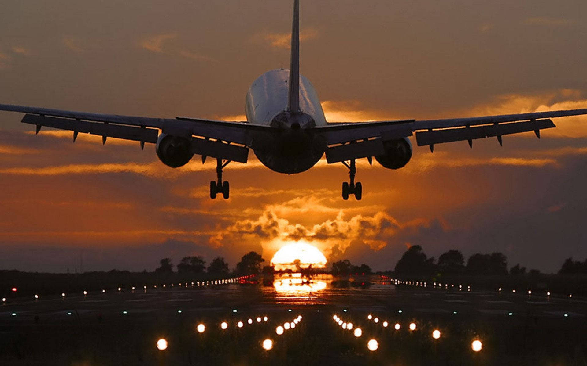 An Incredible Sunset View Of An Airplane Making A Final Descent. Background