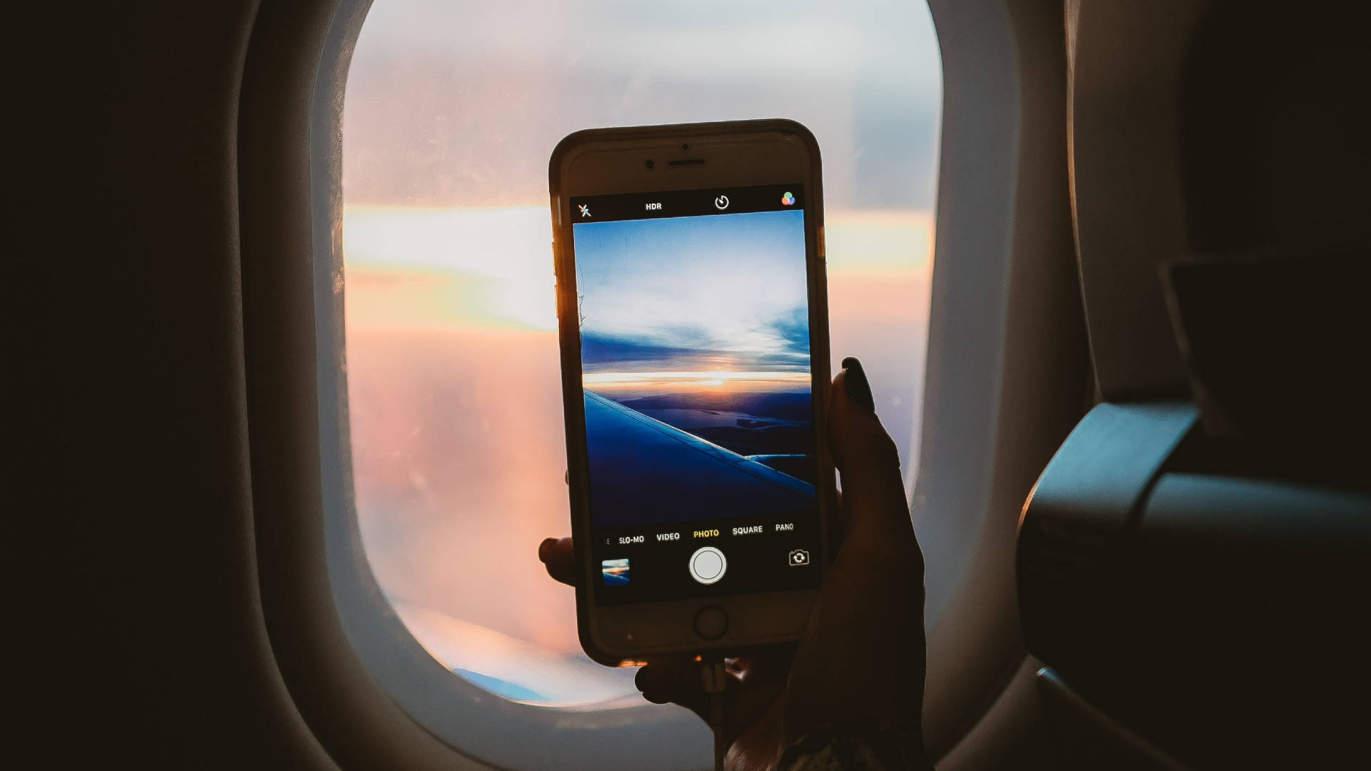 An Iphone In The Plane Window Background