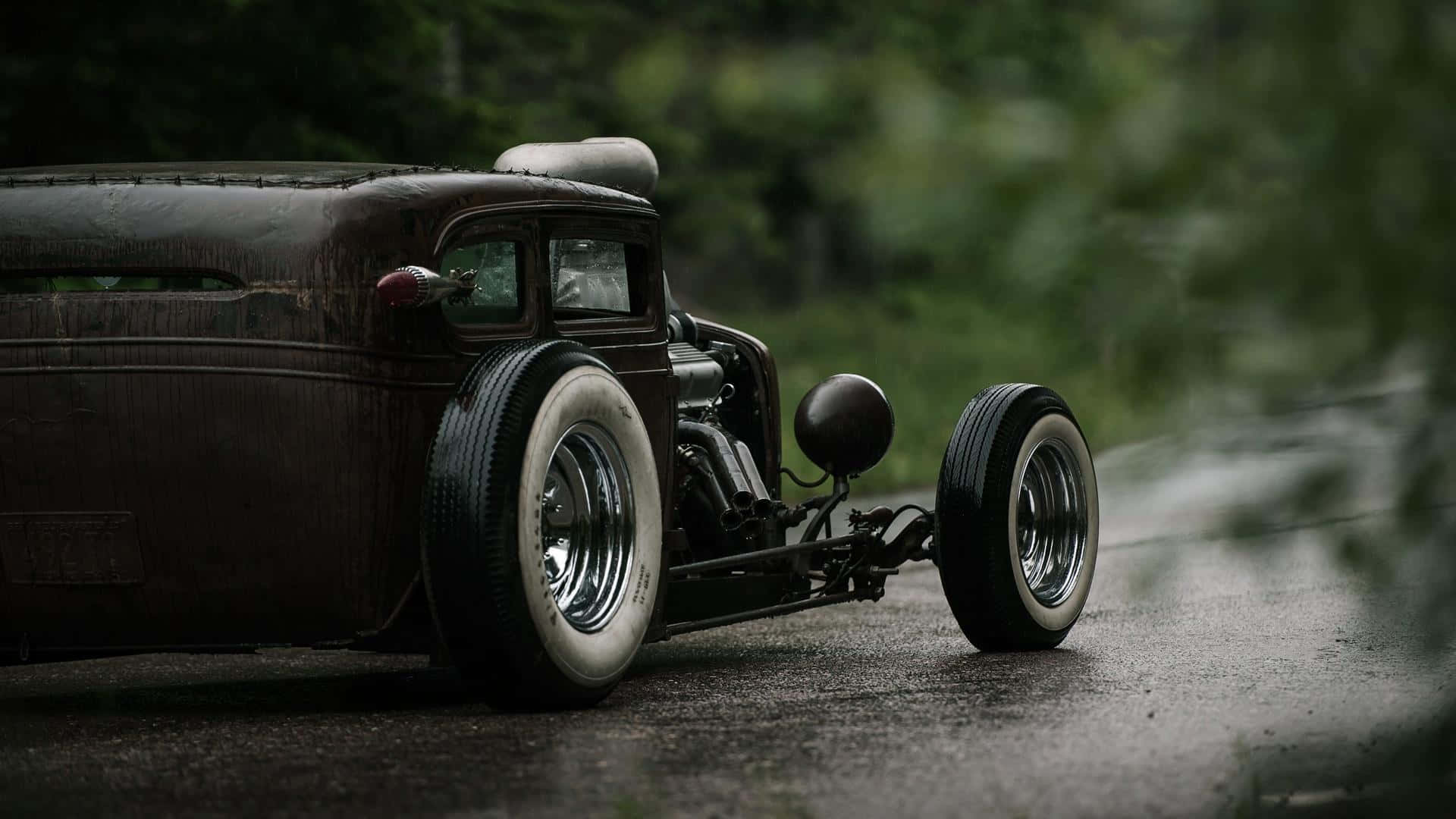 An Old Fashioned Car Is Parked On A Road Background