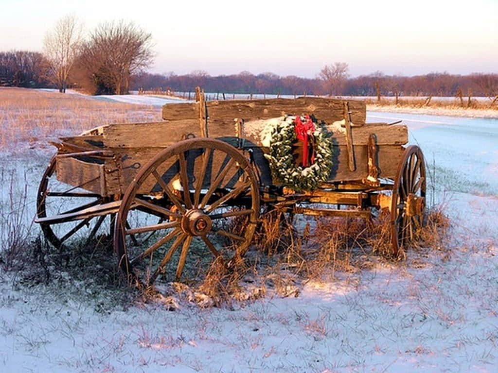 An Old Wagon With A Wreath On It In The Snow Background