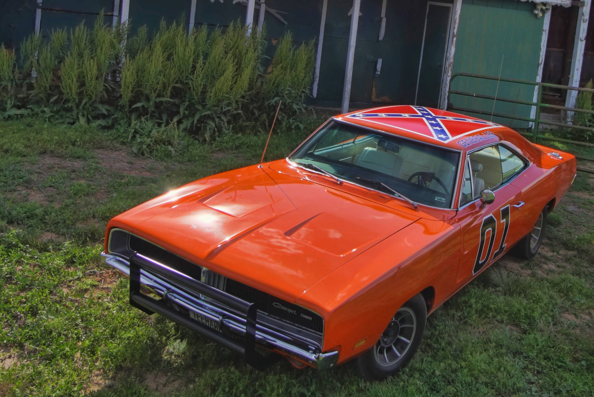 An Orange Dodge Charger Parked In The Grass Background