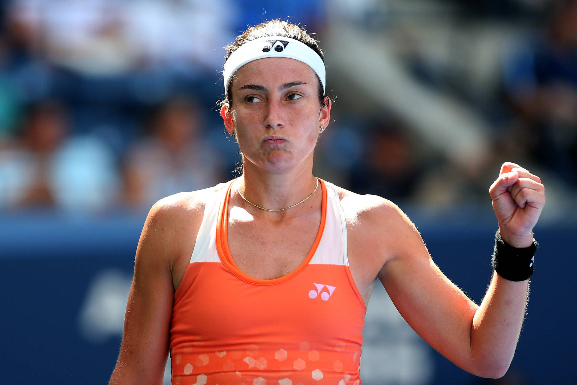 Anastasija Sevastova In Action - Wielding Her Orange Yonex Top On Court Background