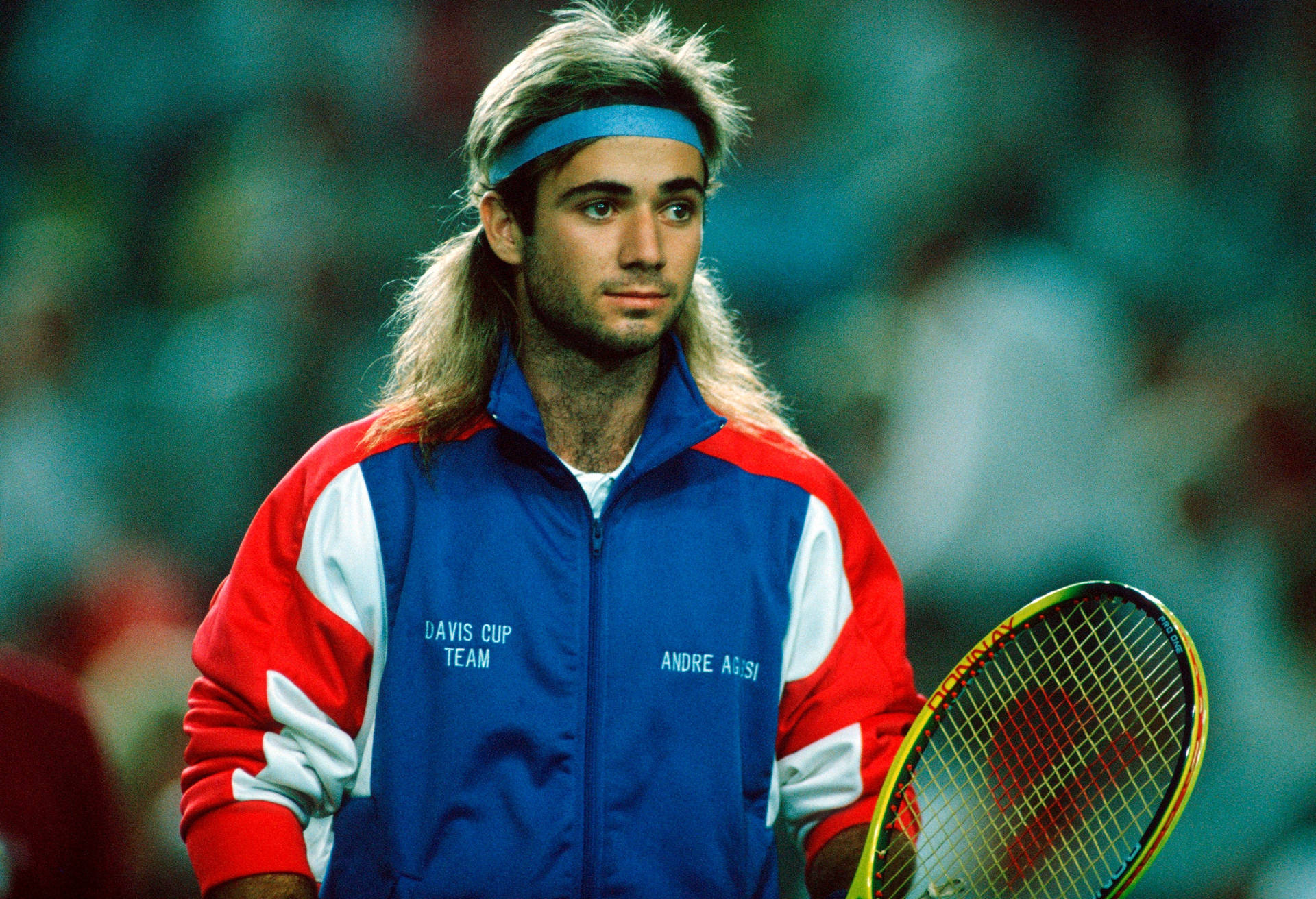 Andre Agassi Sporting Blue Headband On Tennis Court Background