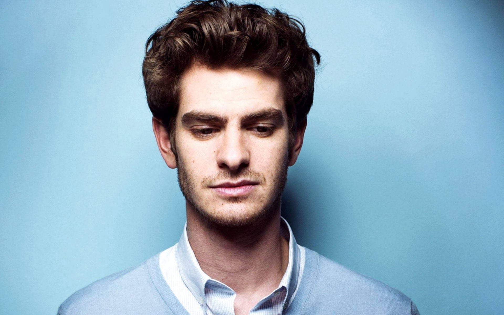 Andrew Garfield Engaged In A Sophisticated Photoshoot Background