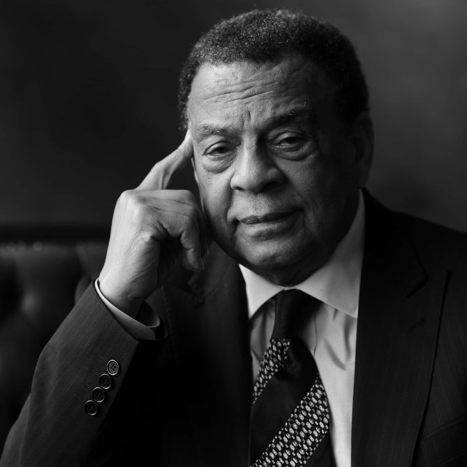Andrew Young Posing With Finger On Temple Background