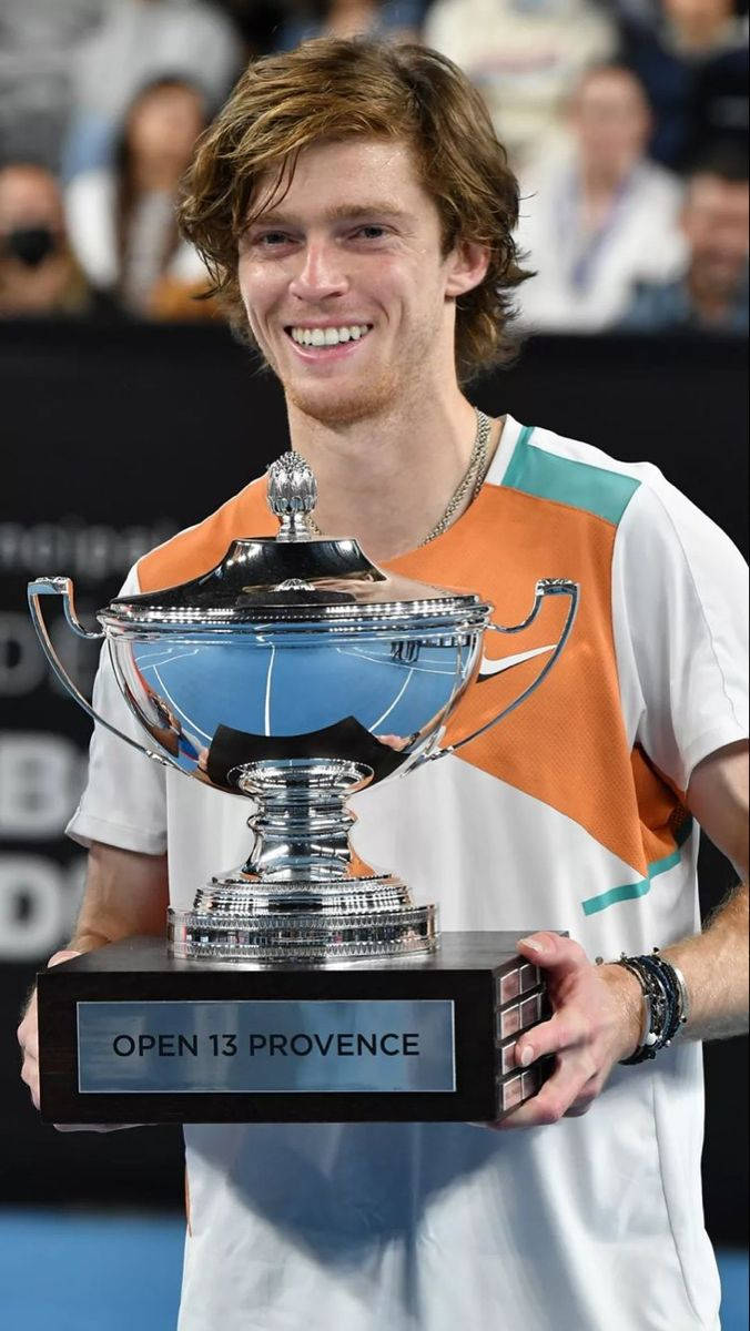 Andrey Rublev Holding A Cup Trophy Background