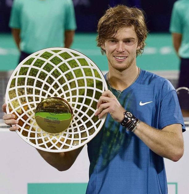 Andrey Rublev Triumphantly Holding Championship Trophy Background