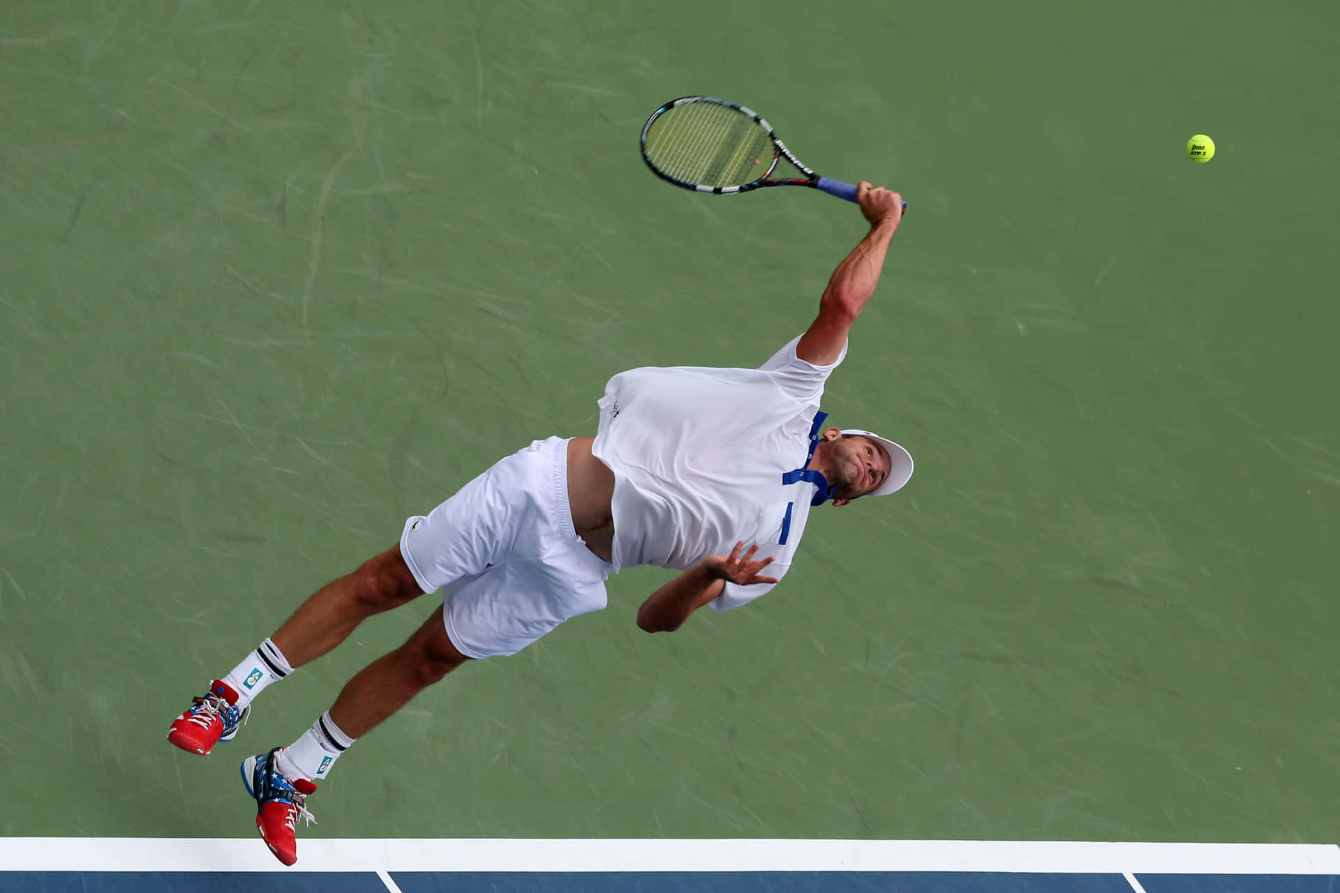 Andy Roddick Delivering A Power-packed Tennis Smash Mid-air. Background