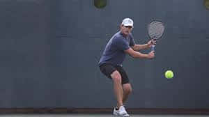 Andy Roddick Looking Down At Ball Background