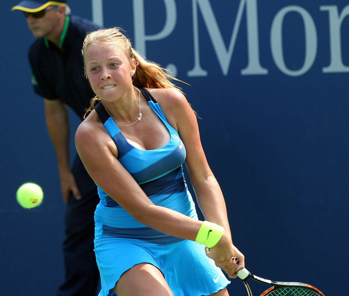 Anett Kontaveit In Blue Hitting Ball Background