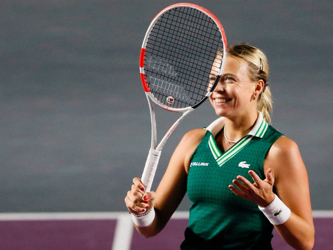 Anett Kontaveit In Green Holding Racket Background