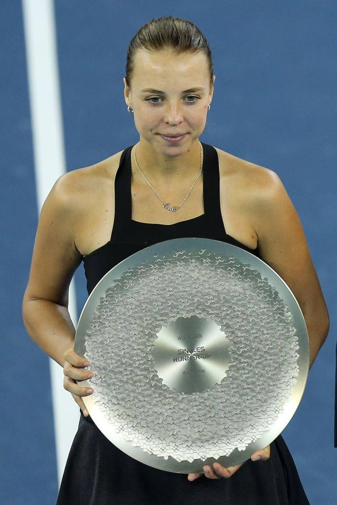 Anett Kontaveit Proudly Holding Up Her Championship Trophy Background