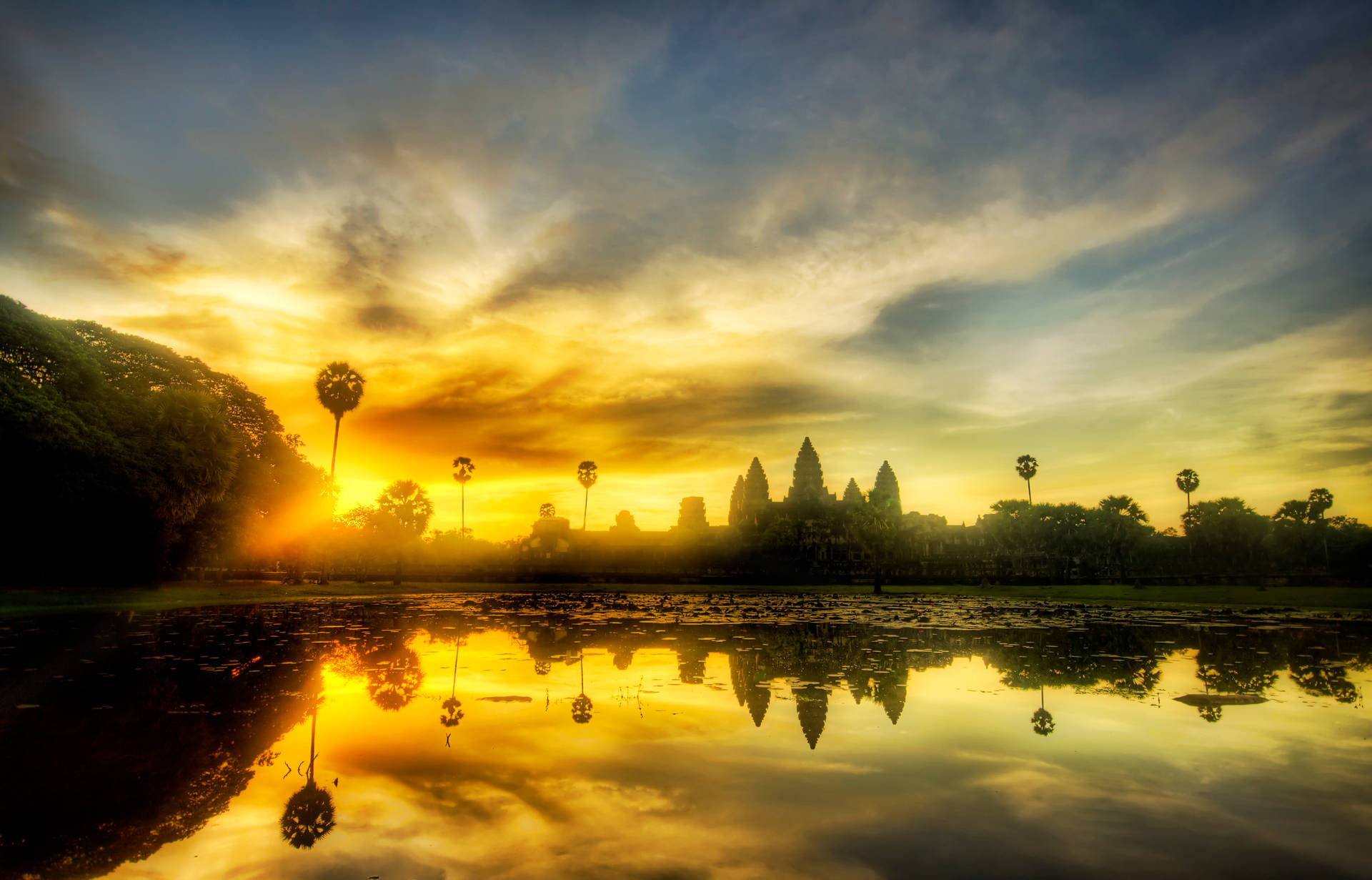 Angkor Wat Beneath A Beautiful Sunset Sky Background